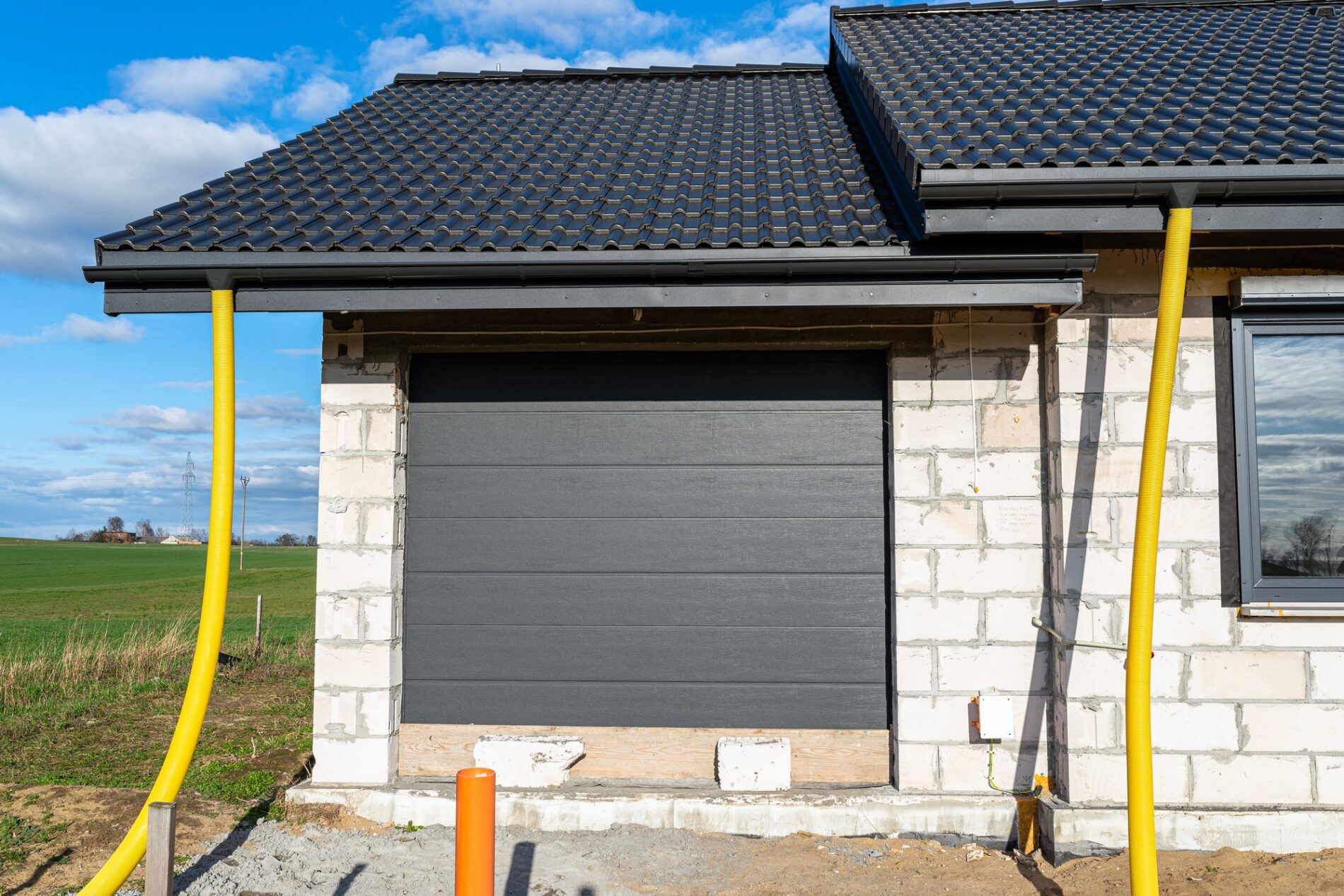 Certainly! Here is a detailed alt text description for the image provided:

---

The image features a close-up view of a yellow PVC pipe with a diameter of 100mm. The pipe appears to be part of a plumbing or drainage system and is securely connected to another section using an industrial-grade coupling. The connection point is reinforced with metal clamps that ensure a tight seal and prevent leaks. The yellow pipe is smooth and cylindrical, with no visible damage or wear, indicating it is relatively new or well-maintained. The background is somewhat blurred but appears to be an industrial or construction setting, with concrete surfaces and other pipes faintly visible. The lighting in the image is natural, casting an even, bright illumination on the yellow pipe, which contrasts sharply with the more subdued tones in the background.

---

Feel free to edit or ask for more details if needed!
